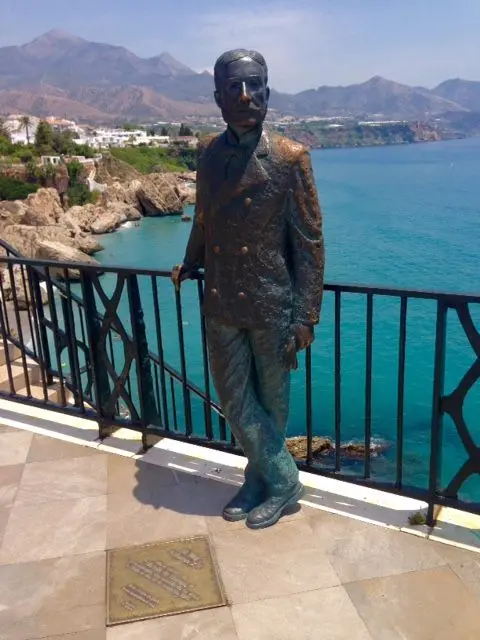 Estatua de bronce de Alfonso XII apoyada en la barandilla del Balcón de Europa