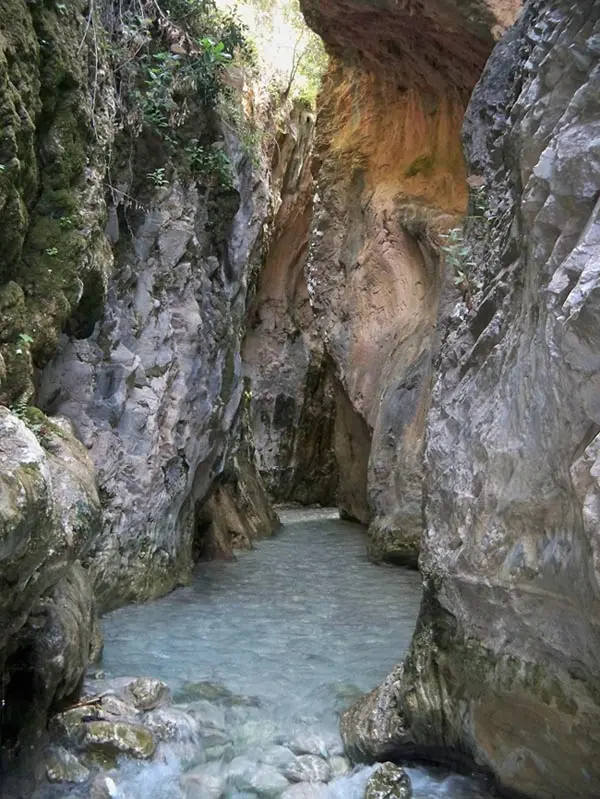 Estrecho paso de Los Cahorros con agua clara entre altas paredes de roca