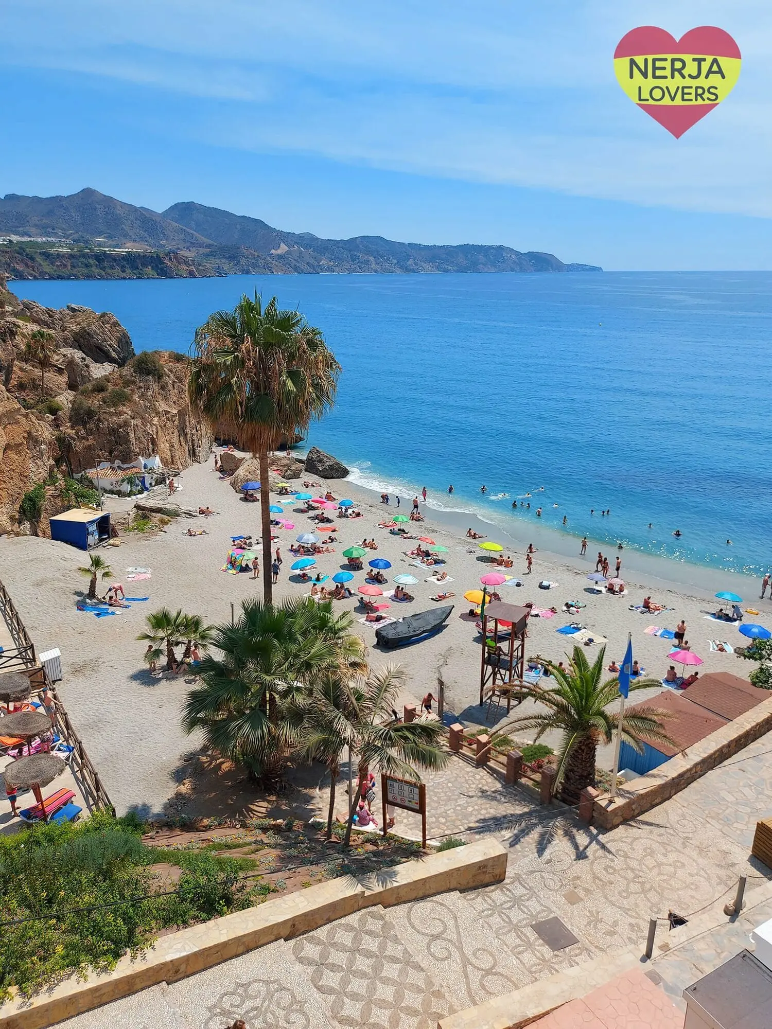 Sombrillas, barcas y torre de socorrista en la playa de Calahonda, bajo el mirador