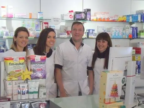Equipo de la Farmacia Chíllar con bata blanca detrás del mostrador