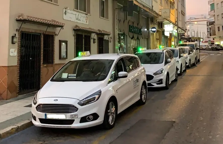 Taxis con la luz verde de libre esperando en una calle de Nerja al anochecer