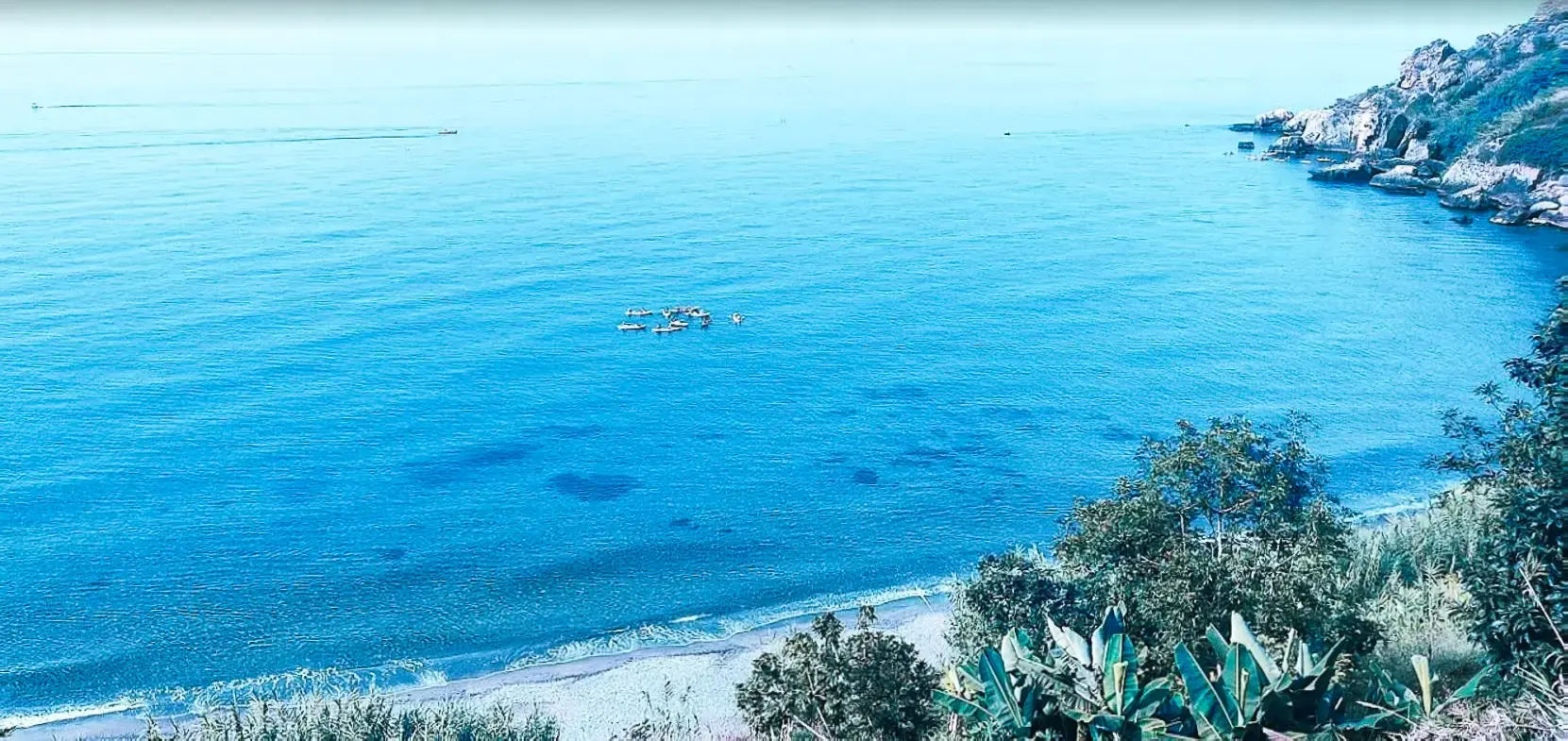 Kayaks en el mar en calma frente a La Caleta de Maro, vista desde la ladera