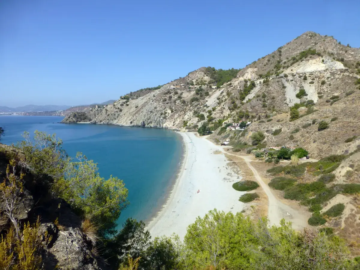 Larga playa de arena clara de El Cañuelo bajo las laderas del paraje de Maro-Cerro Gordo