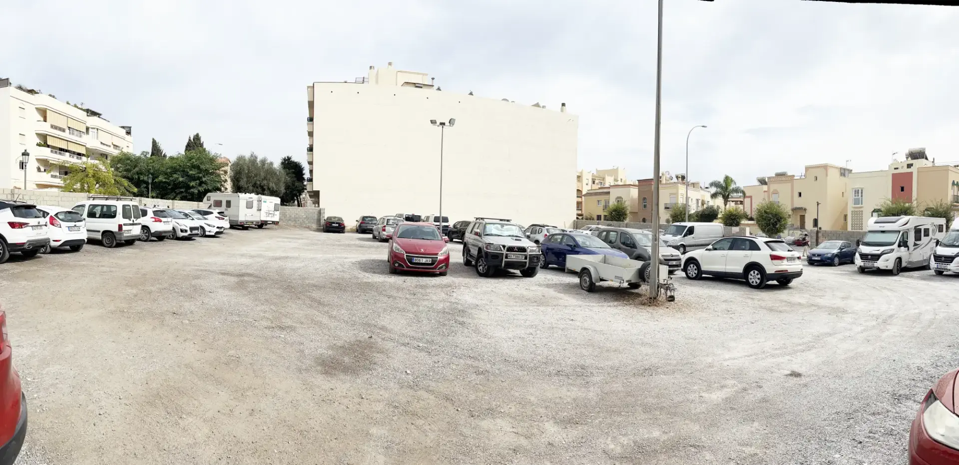 Vista panorámica del aparcamiento al aire libre cerca de la playa La Torrecilla con autocaravanas al fondo
