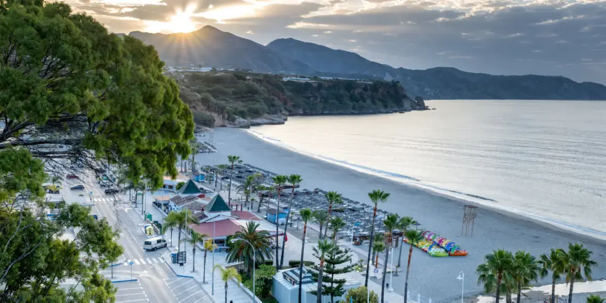 Atardecer sobre la playa de Burriana, con el paseo, las palmeras y los hidropedales en la orilla