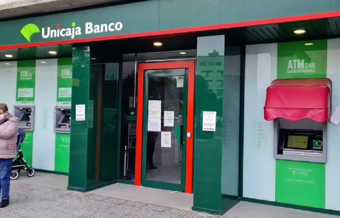 Entrada del Banco Unicaja con cajeros automáticos de 24 horas a ambos lados de la puerta