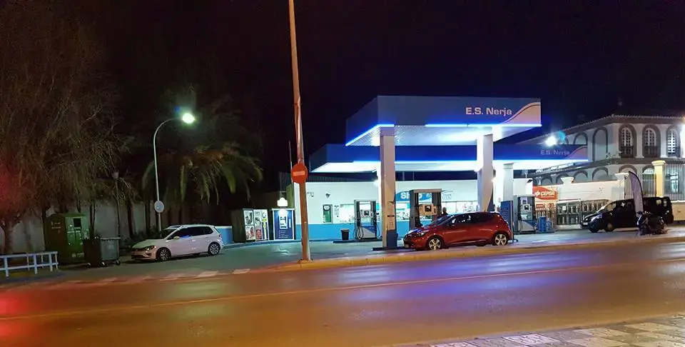 Gasolinera de Nerja de noche con la marquesina iluminada y un coche repostando