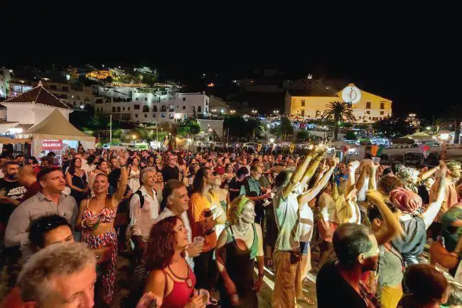 Público bailando ante el escenario en un concierto nocturno en Frigiliana
