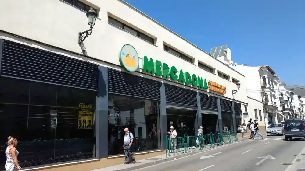 Fachada de Mercadona Nerja en una calle del centro, con peatones y el cartel de horario