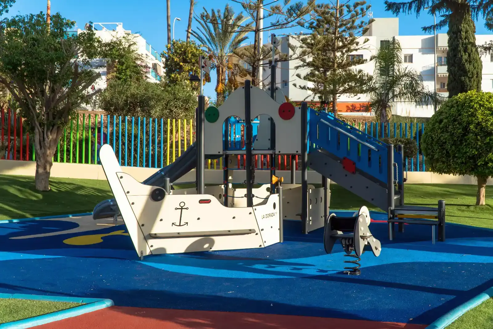 Juego infantil con forma de barco y tobogán sobre suelo de caucho azul en el Parque Verano Azul