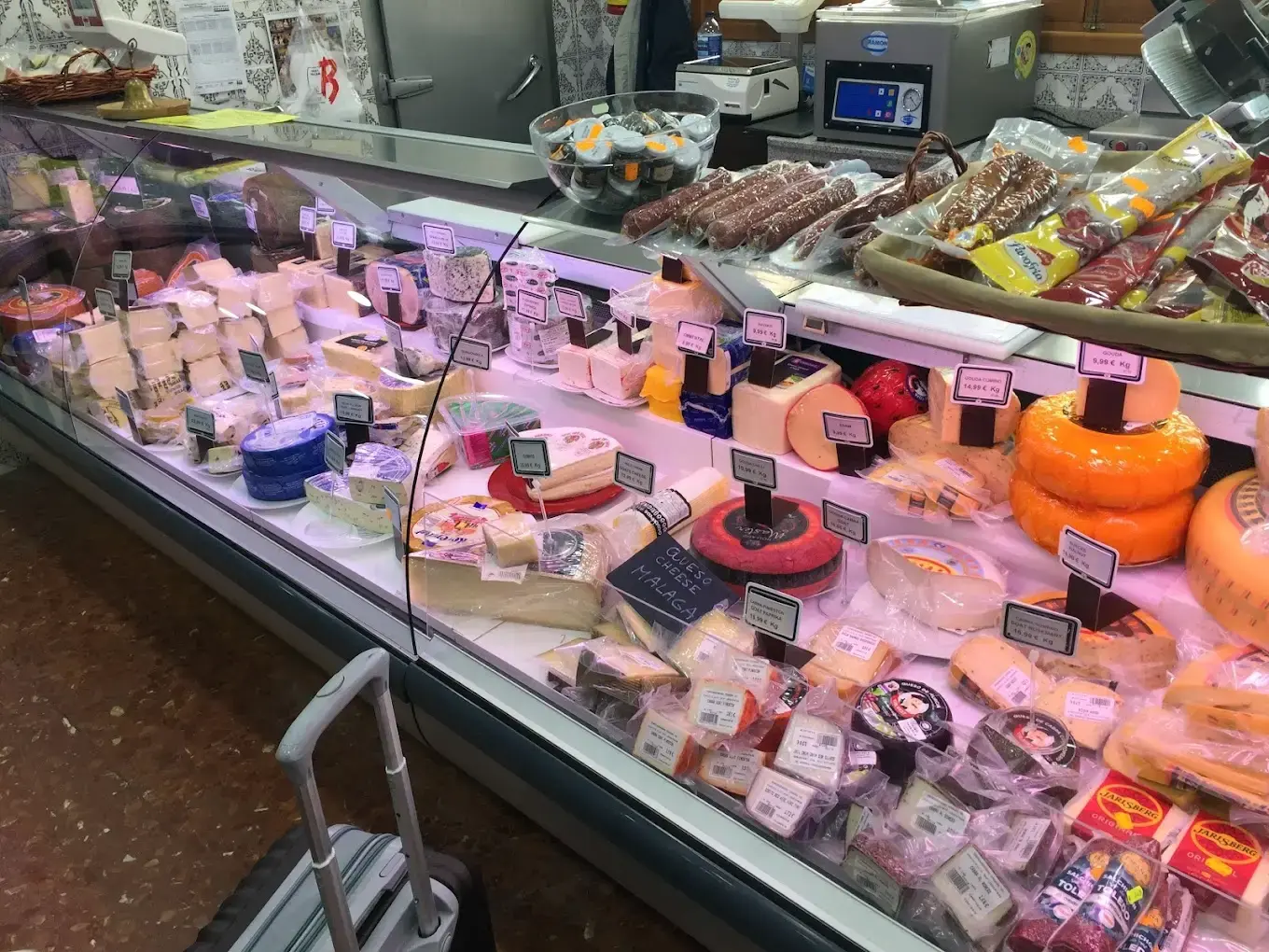 Vitrina refrigerada con quesos variados y embutidos con sus precios