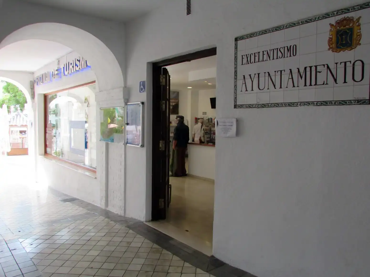 Entrada al Excelentísimo Ayuntamiento bajo los soportales, junto a la Oficina de Turismo