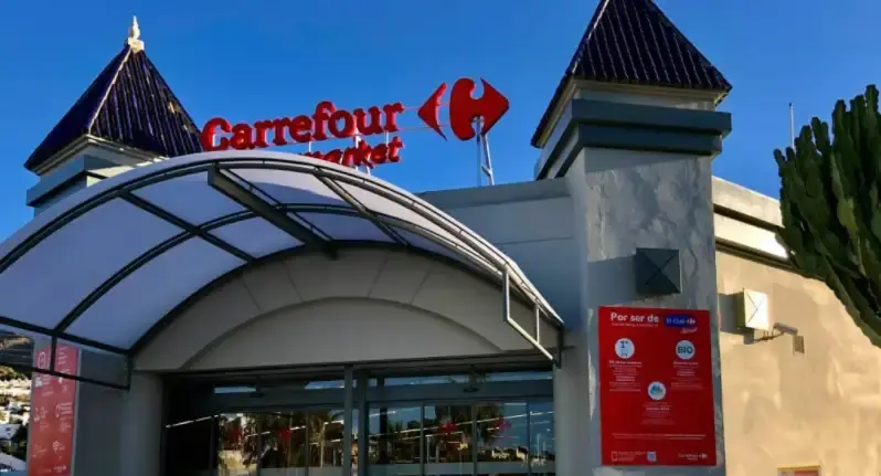 Entrada del Carrefour Market de El Capistrano, en la carretera de Almería, con su marquesina curva