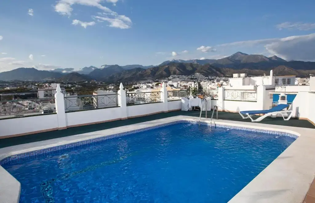 Piscina en la azotea del Hotel Bajamar Centro con vistas al pueblo y a la sierra