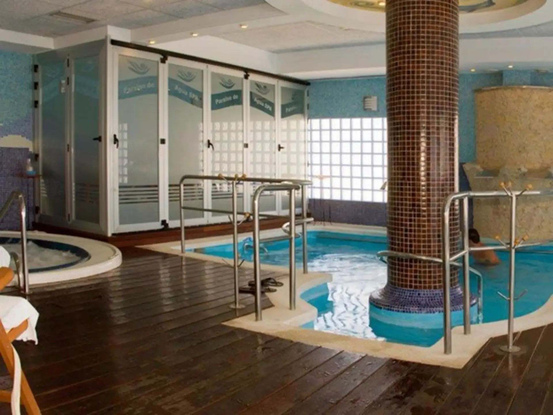 Zona de spa con piscina de hidromasaje, columna de gresite y jacuzzi redondo