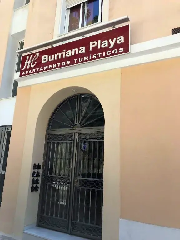 Rótulo de HC Burriana Playa Apartamentos Turísticos sobre una puerta de forja en arco