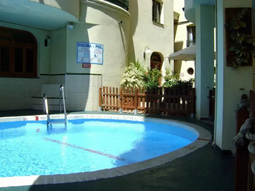 Piscina pequeña en el patio interior de Apartamentos Mediterraneo, con escalerilla y plantas