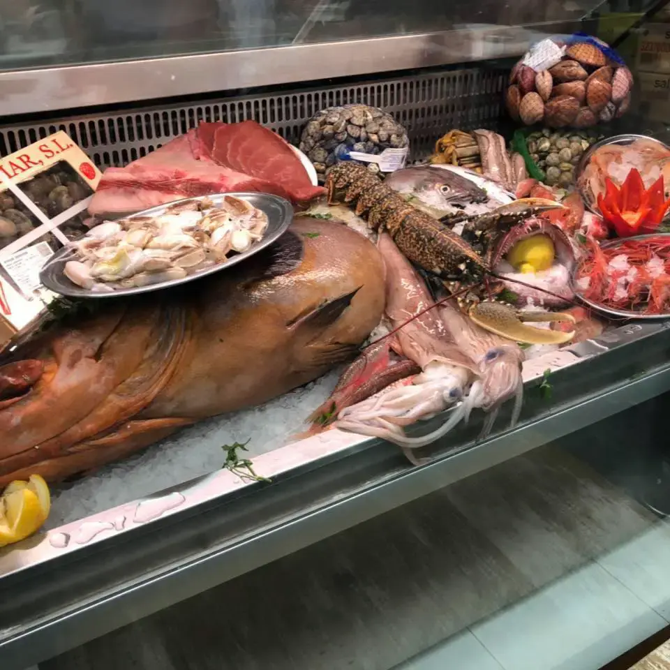 Expositor de marisco con langosta, calamares, almejas, atún y un gran pescado