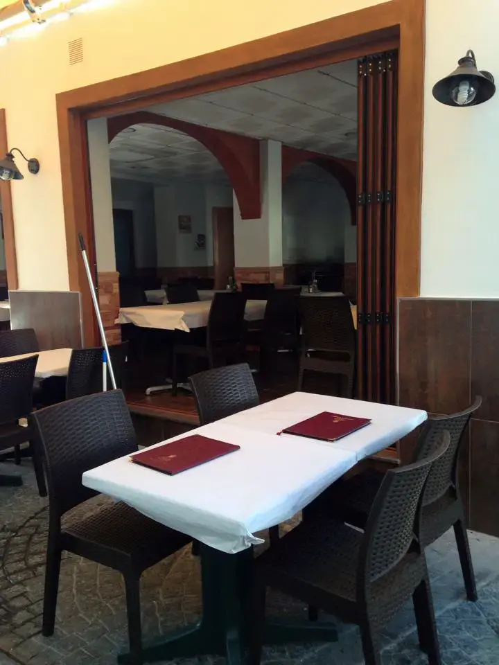 Mesa de la terraza con cartas granates junto a la entrada al comedor