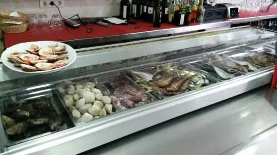 Vitrina de la barra con almejas, mejillones, pescado y un plato de vieiras