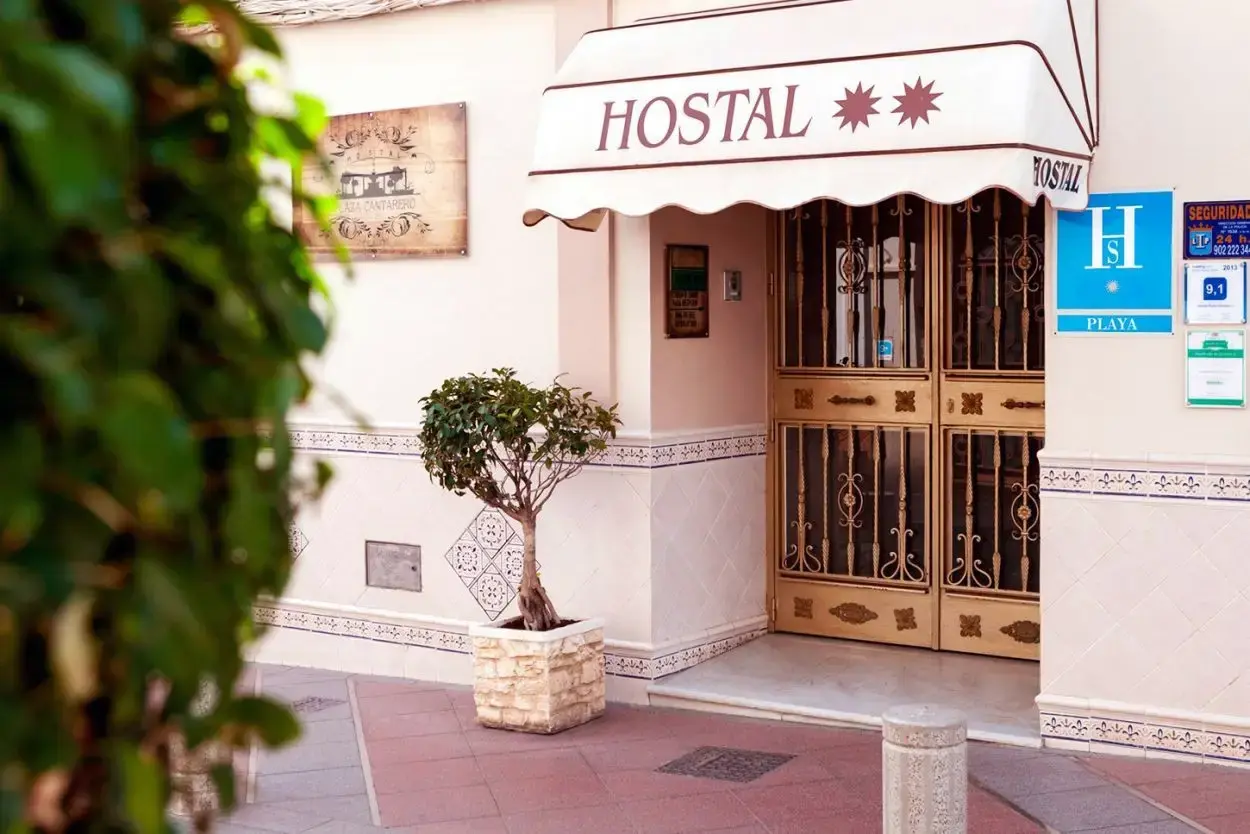 Entrada del Hostal Boutique Plaza Cantarero con toldo, rejas de forja y placa de hostal