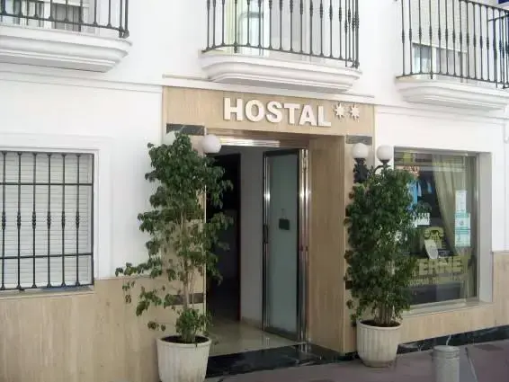Entrada del hostal en la calle Pintada, con rótulo de dos estrellas y árboles en macetas