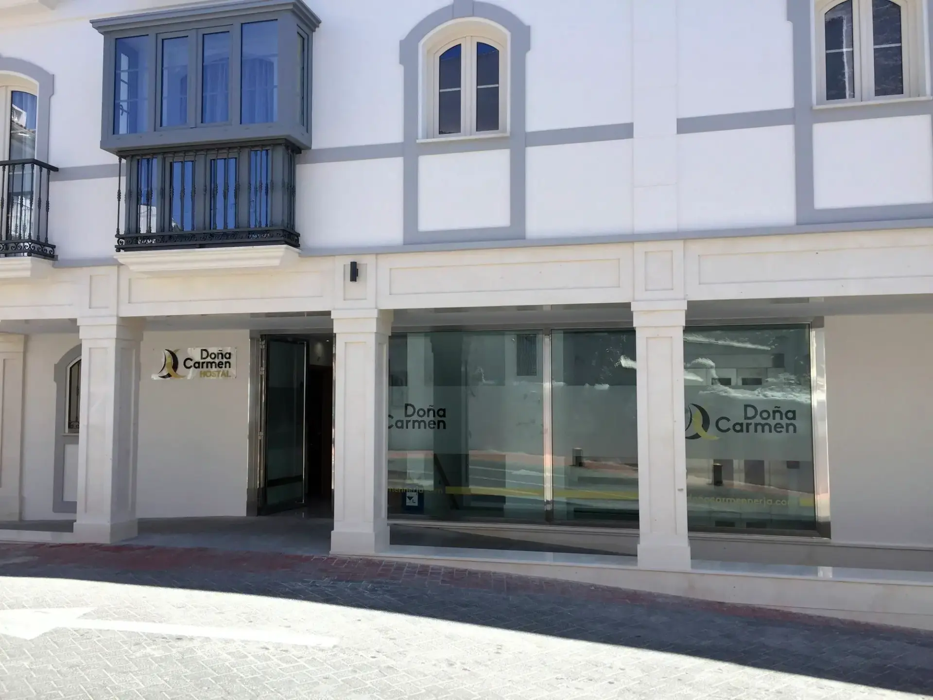 Entrada acristalada en la planta baja del edificio, con el rótulo de Doña Carmen