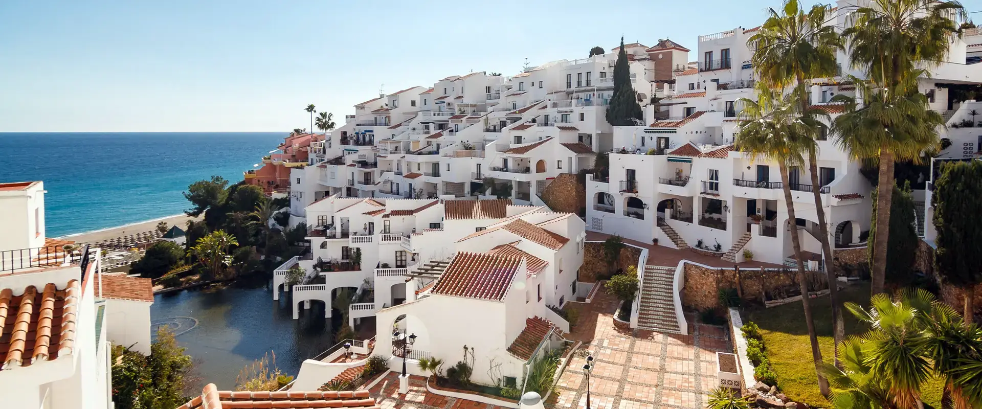 Urbanización de casas blancas escalonadas junto al mar en la costa de Nerja