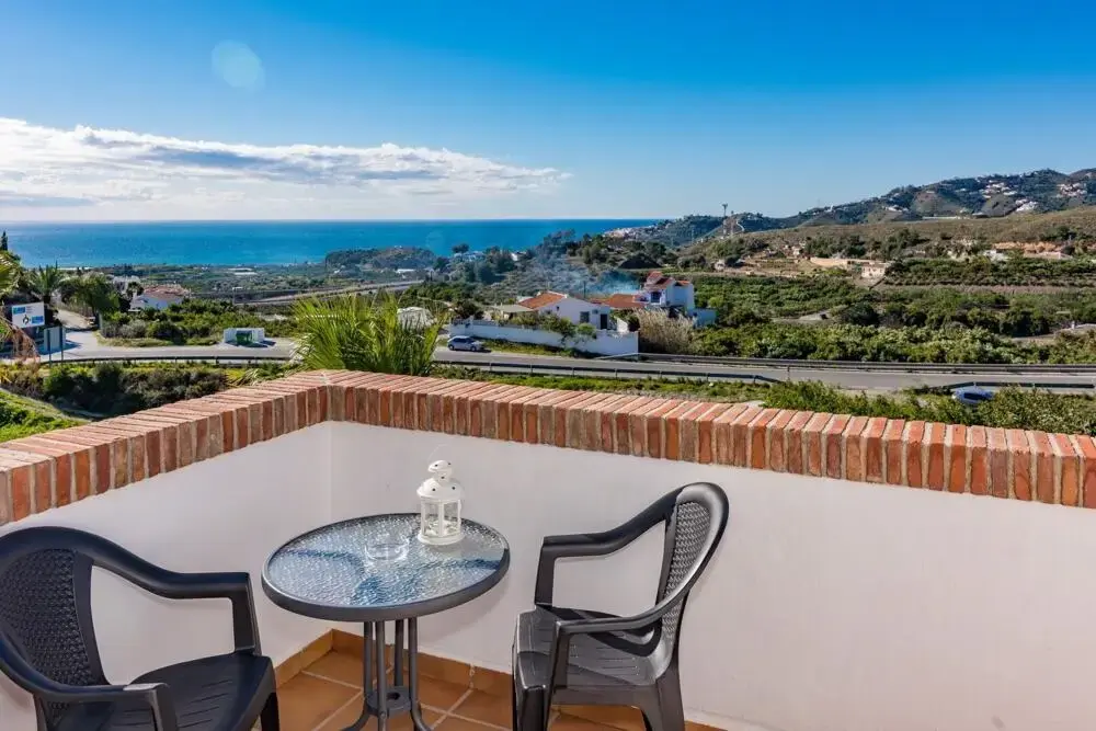 Terraza con mesa y dos sillas frente a los campos y el mar entre Nerja y Frigiliana