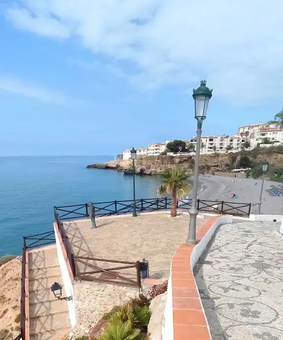 Mirador con la pequeña estatua de Chanquete, farolas y la playa de Nerja al fondo