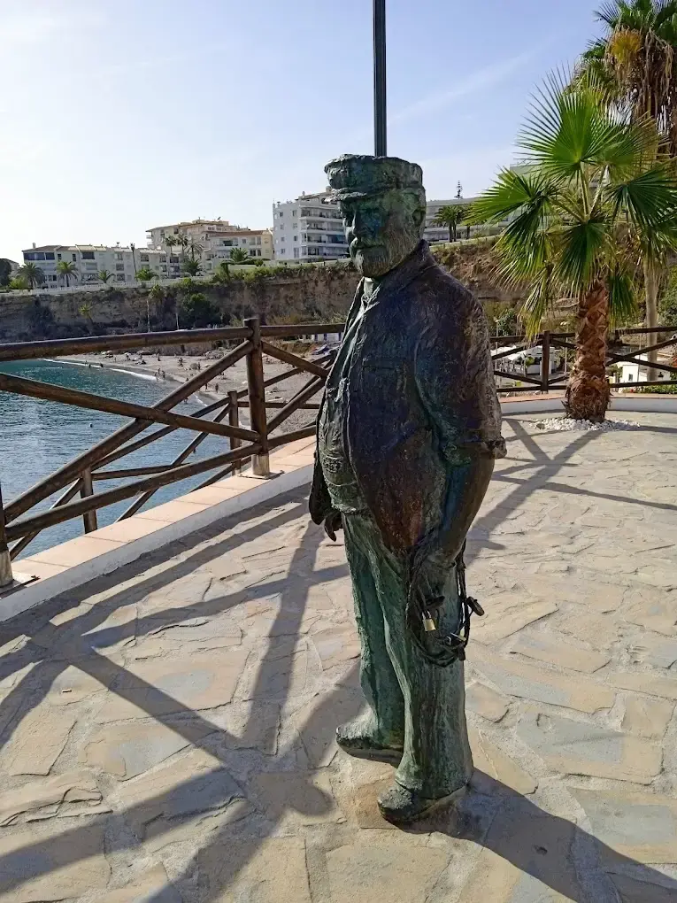 Figura de bronce de Chanquete con gorra de marinero sobre el mirador empedrado