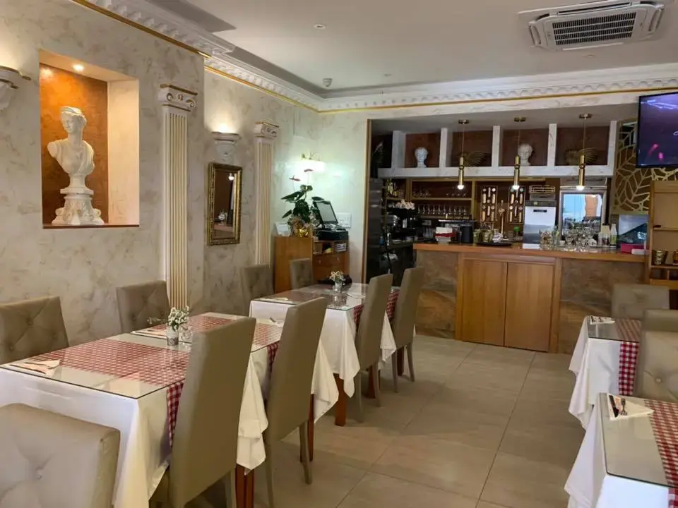 Comedor con columnas, busto clásico en una hornacina y la barra al fondo
