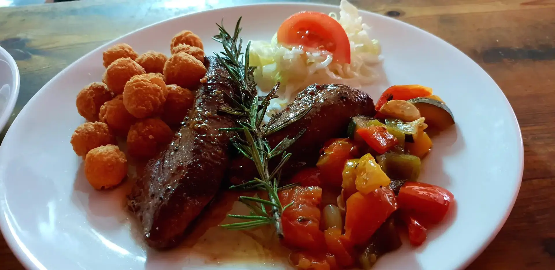 Plato de carne a la plancha con romero, verduras salteadas y croquetas de patata