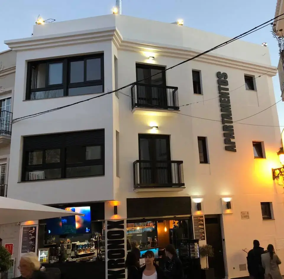 Fachada de Kronox Plaza iluminada al atardecer, con la barra exterior y su pantalla