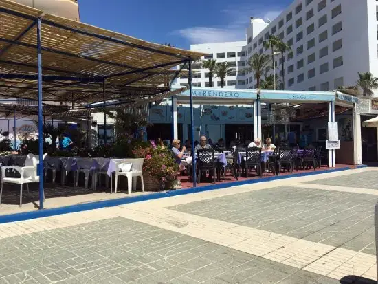 Merendero Cobos visto desde el paseo, con su terraza cubierta y hoteles altos detrás