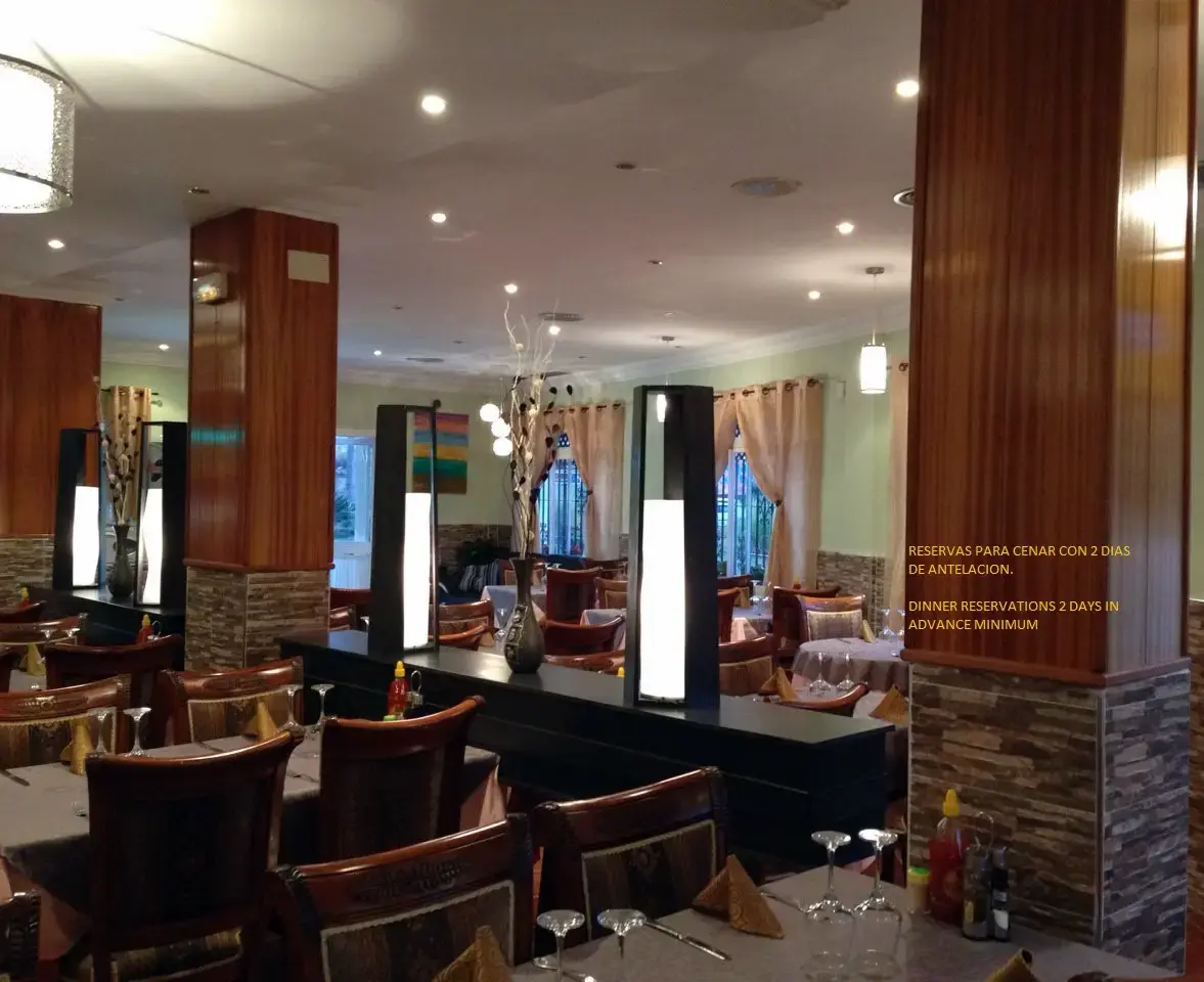 Sala con columnas y aviso de reservas para cenar con dos días de antelación