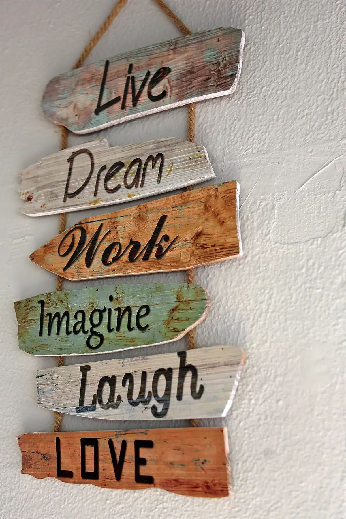 Cartel decorativo de tablillas de madera con palabras en inglés colgado de una cuerda