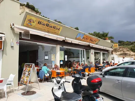 Terraza con clientes bajo los toldos de Yuu Taley y del local vecino WaWaWok