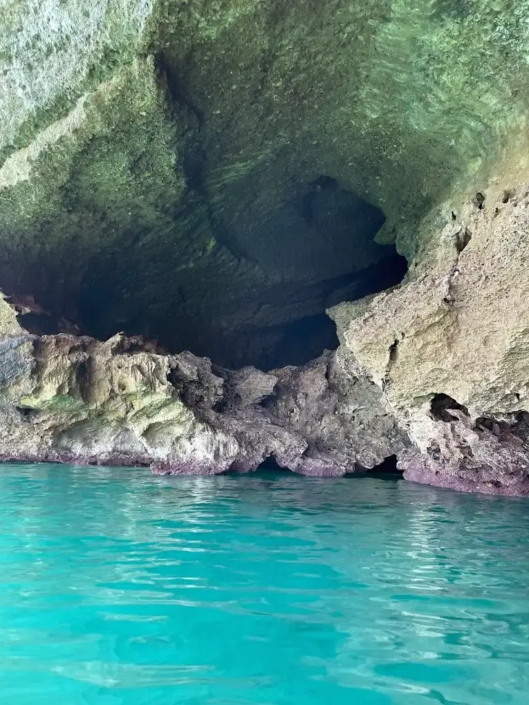 Bóveda de roca y agua turquesa en la Cueva del Lobo Marino, vista desde el kayak