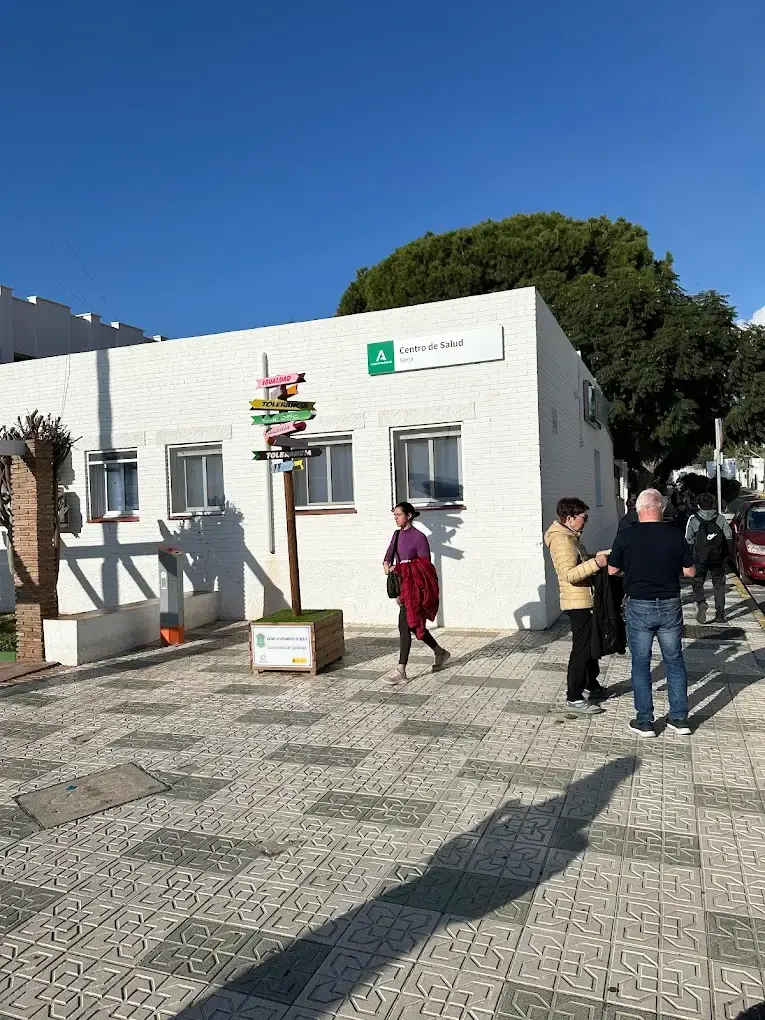 Edificio blanco de una planta con el rótulo de Centro de Salud y una plaza con señales indicadoras