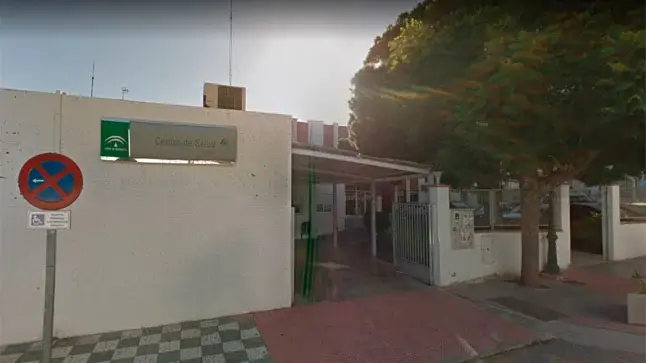 Fachada del centro de salud junto a una señal de prohibido aparcar y la entrada cubierta