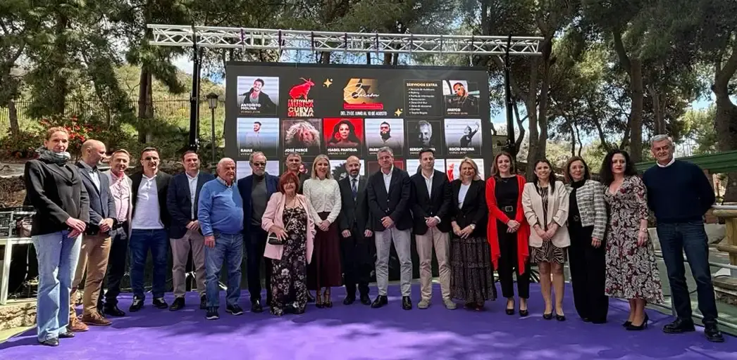 Presentación del cartel del festival con un grupo de personas sobre una alfombra morada