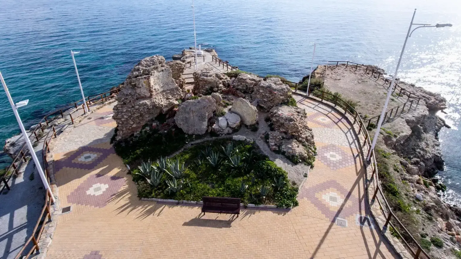 Mirador visto desde arriba, con los restos de la torre, jardín de pitas y suelo de baldosas