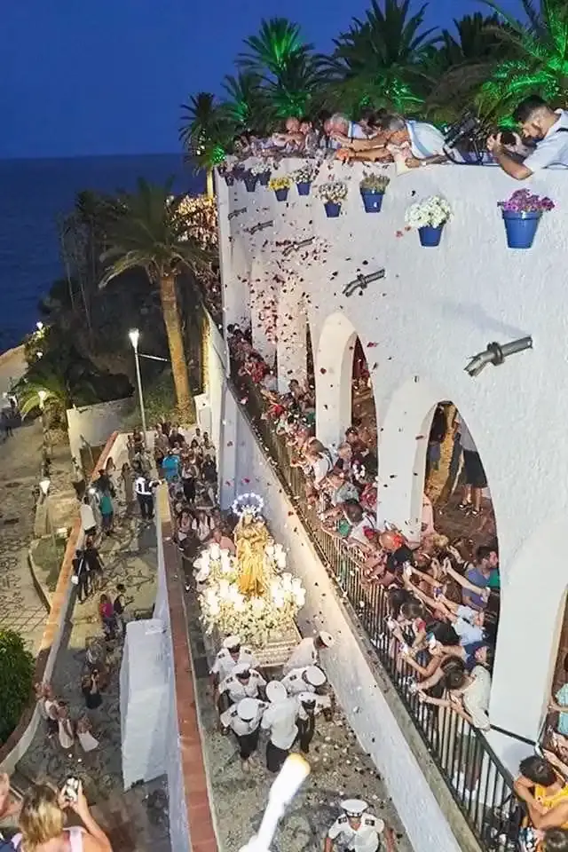 Lluvia de pétalos desde los arcos sobre la procesión de la Virgen bajando hacia el mar