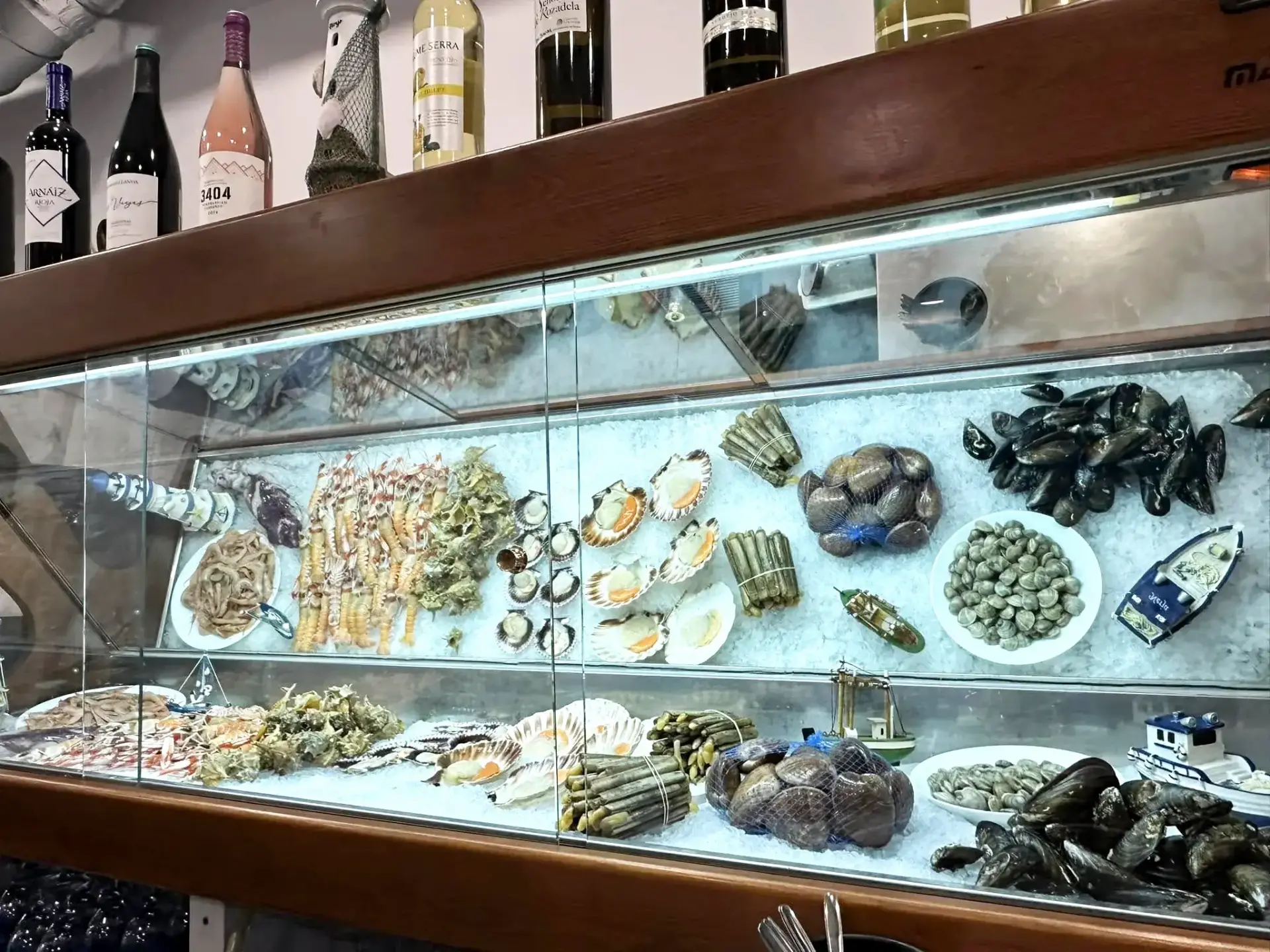 Vitrina refrigerada con marisco fresco: vieiras, navajas, mejillones, almejas y gambas