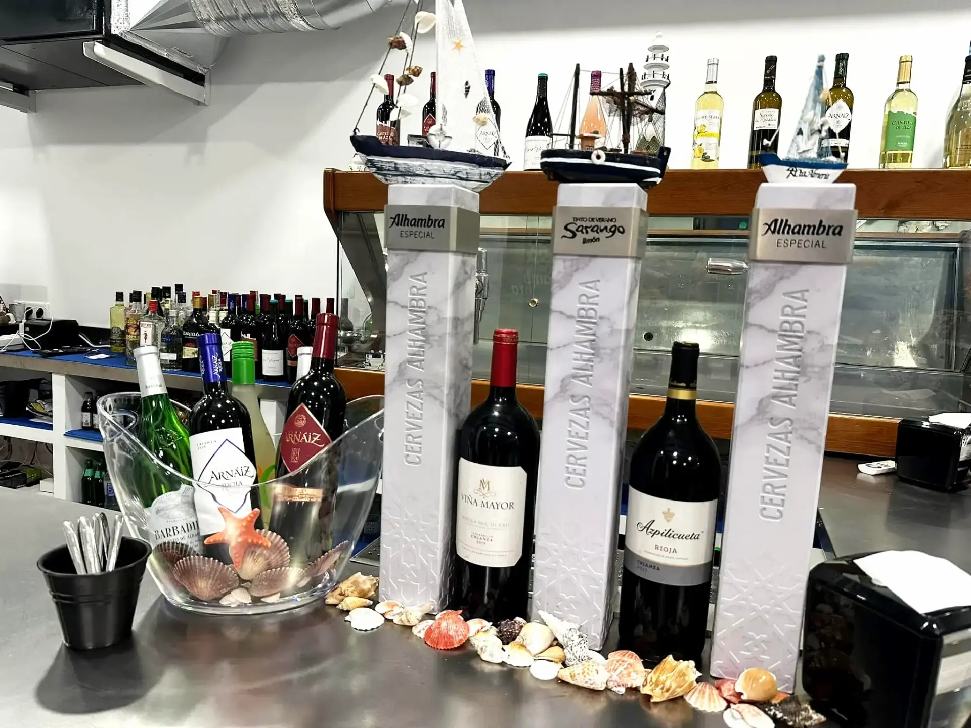 Botellas de vino y columnas de cerveza decoradas con conchas sobre el mostrador