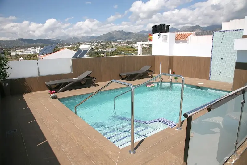Piscina en la azotea con tumbonas y vistas a las sierras de Nerja