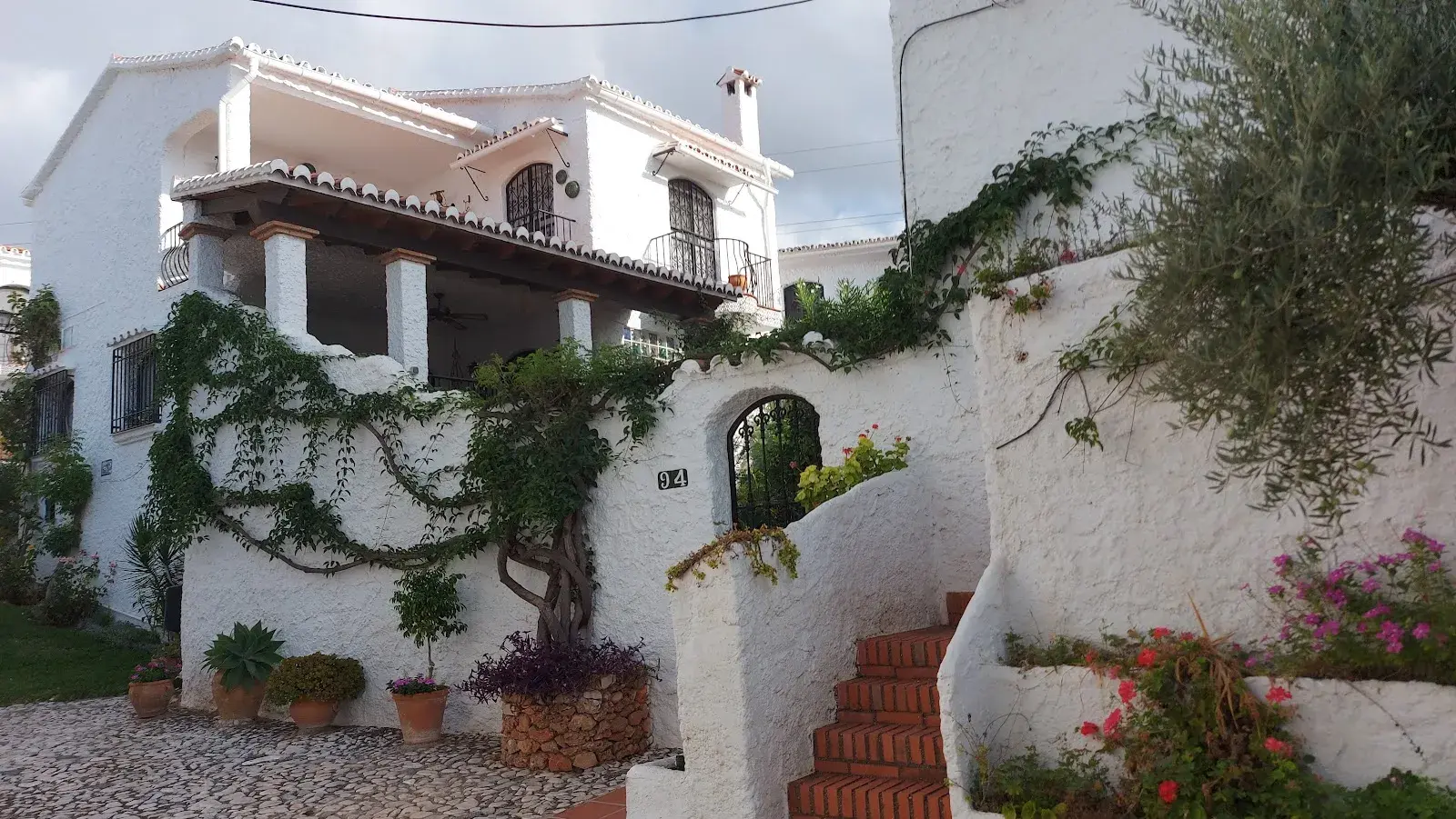 Casas blancas de estilo andaluz con buganvillas y escaleras de barro en Capistrano