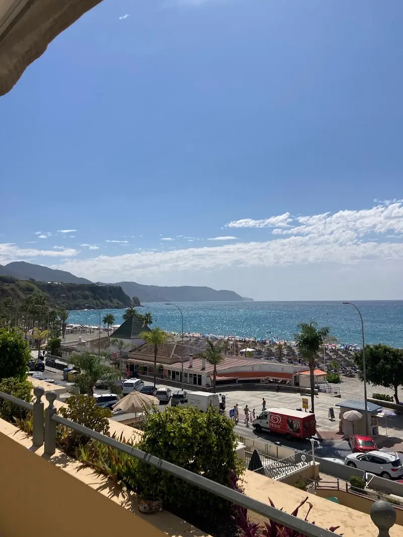 Vista desde un balcón al paseo de Burriana, la playa y los acantilados hacia Maro