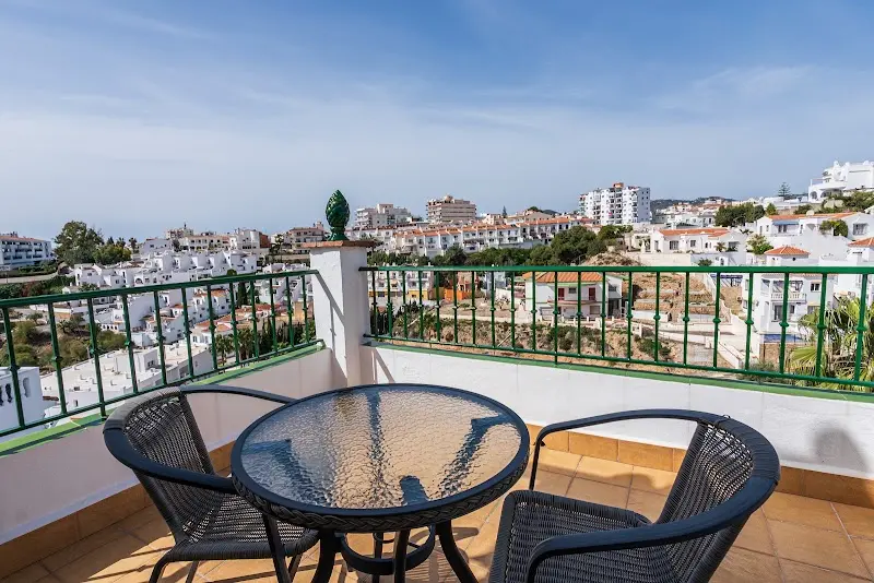 Terraza con mesa de cristal y dos sillas, con vistas a las urbanizaciones blancas de Nerja